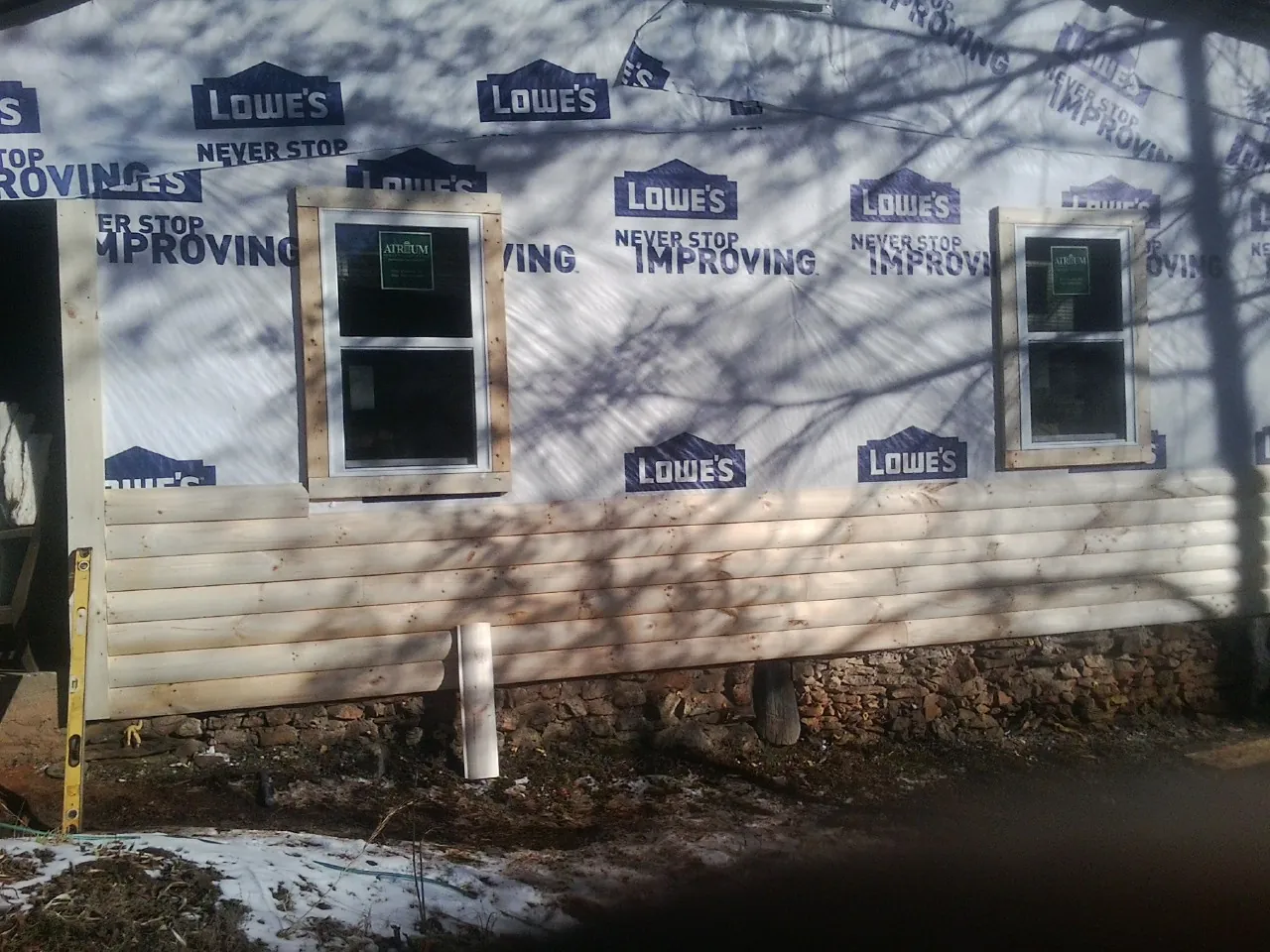 House wrap and new log siding going up on an exterior wall in La Vista