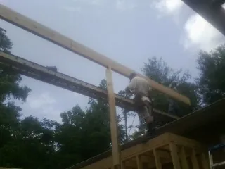 Carpenter setting a ridge beam over a new addition frame — Ice Dam Removal by Roofing Brothers in La Vista