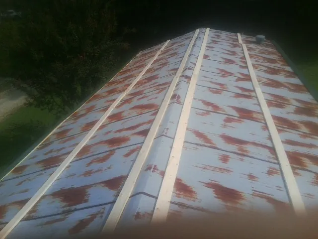 Rusted metal roof panels with new wood purlins before replacement — Storm Damage Roof Repair in La Vista by Roofing Brothers